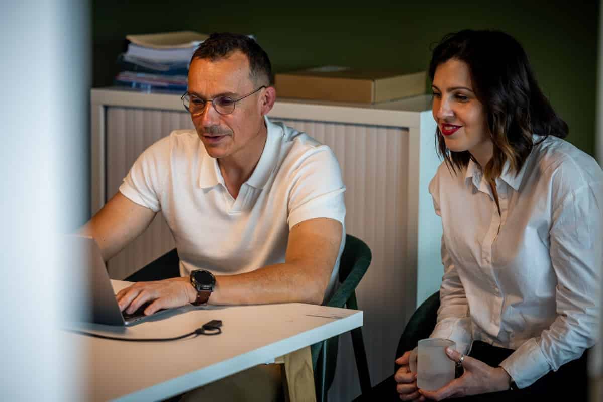 2 membres d'Ubicité travaillant sur un ordinateur portable